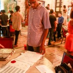 Visitante observa Cadernos de Inspiração no Salão Assyrio (Créditos: Nathalia Werneck)