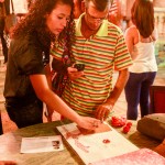 Aluna Tamara Assis mostra um dos Cadernos de Inspiração a um visitante no Salão Assyrio (Créditos: Nathalia Werneck)