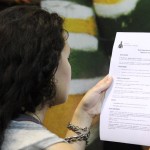 Jovem lê o termo de boas-vindas da Spectaculu (Créditos: Gustavo Carlos)