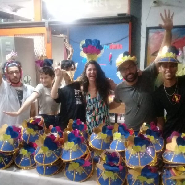 Aderecistas e a coordenadora do Núcleo de Trabalho Carla Vilardo posam em frente a adereços